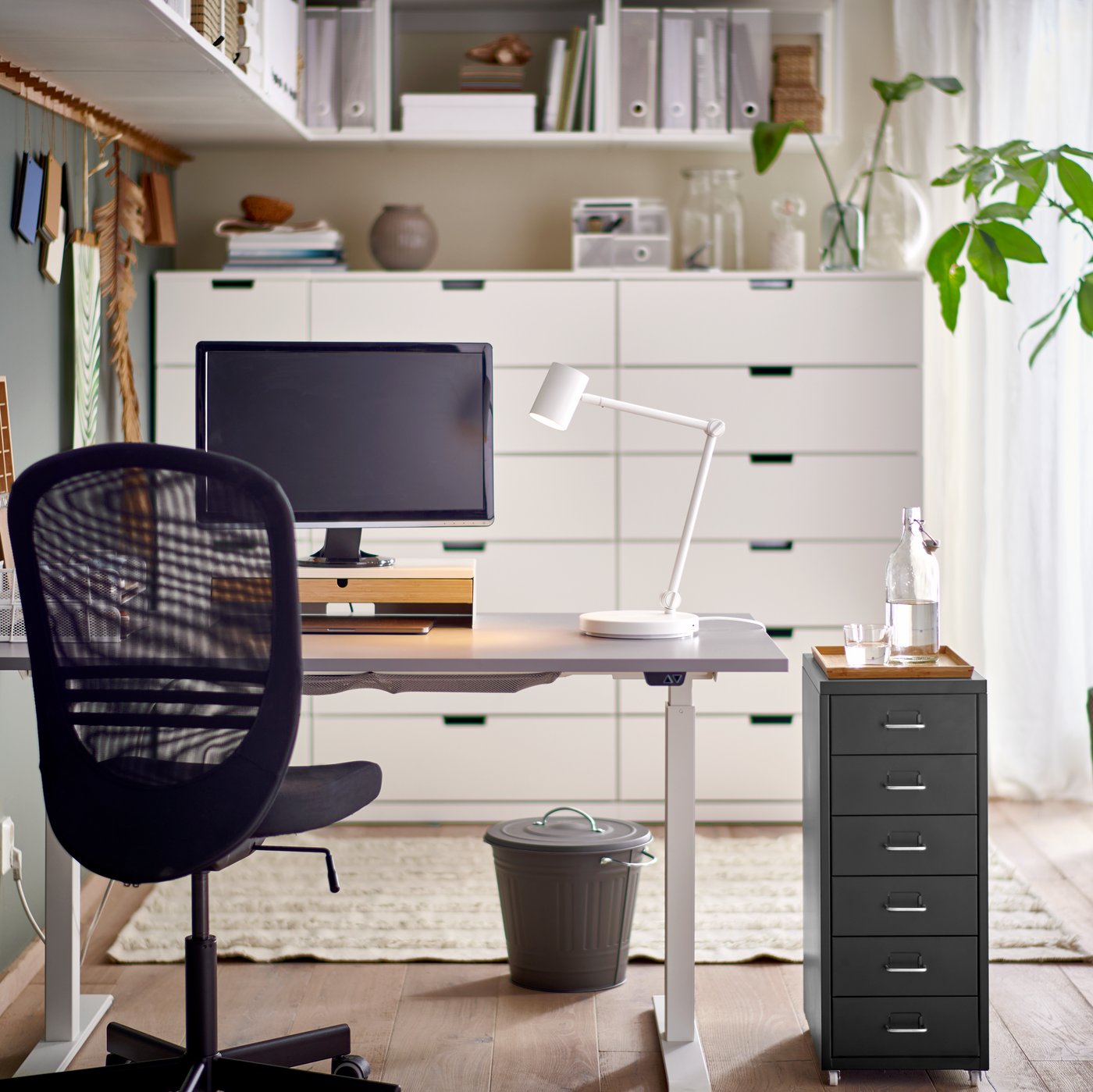 A clear glass FRAMPRESSA vase in the home office