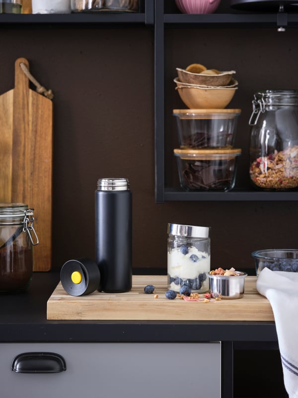 IKEA UNDERSÖKA black insulated travel mug and IKEA UNDERSÖKA glass container in the kitchen.