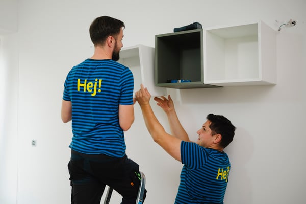 Pracownicy , wolontariusze IKEA montujący meble do ściany