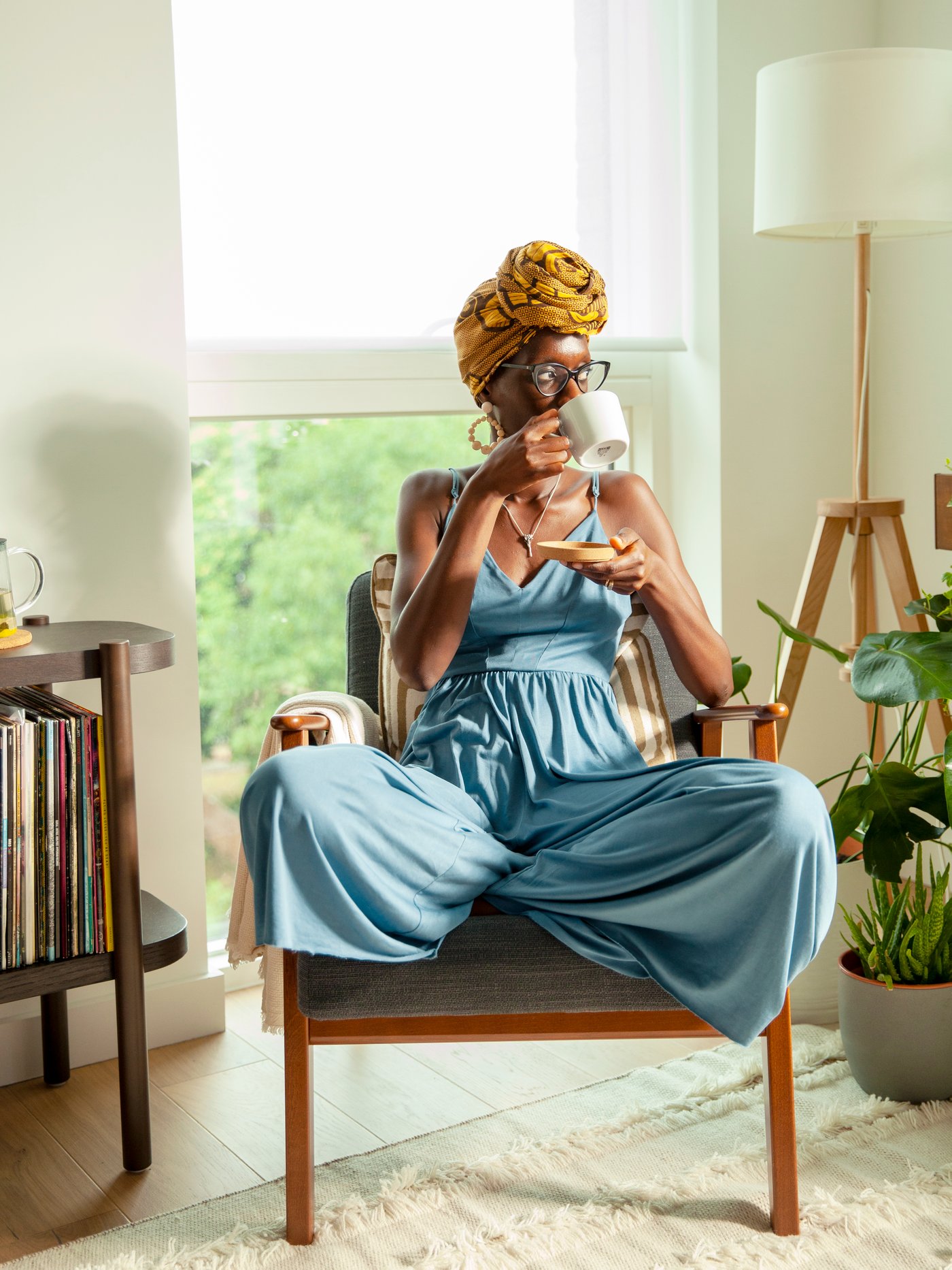 Une femme détendue assise dans un fauteuil boit du thé dans une tasse IKEA 365+.