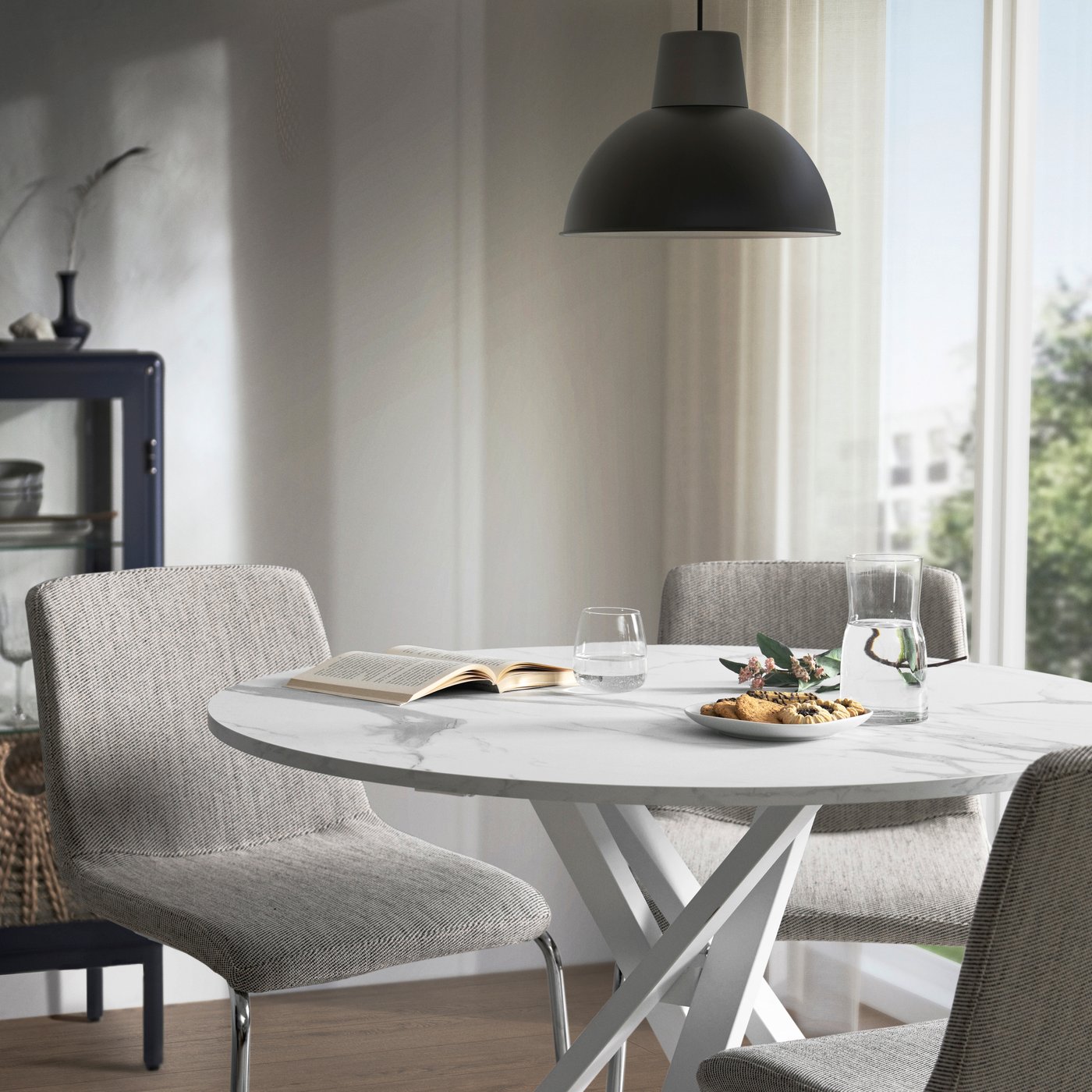 Valoisassa ruokailutilassa on valkoinen MARIEDAMM-pöytä, jonka pöytälevyssä on marmorikuvio.
