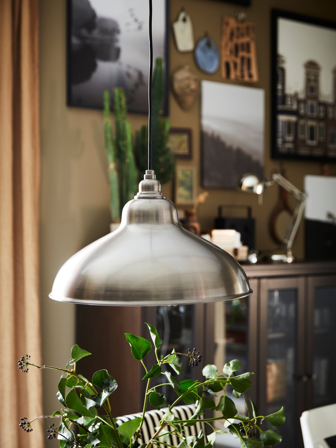 An ANKARSPEL pendant lamp hangs above some cuttings from green plants used as a decoration in a room.