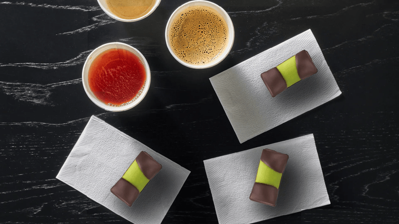 Un piano su cui sono posati tre dolcetti svedesi e delle bevande 