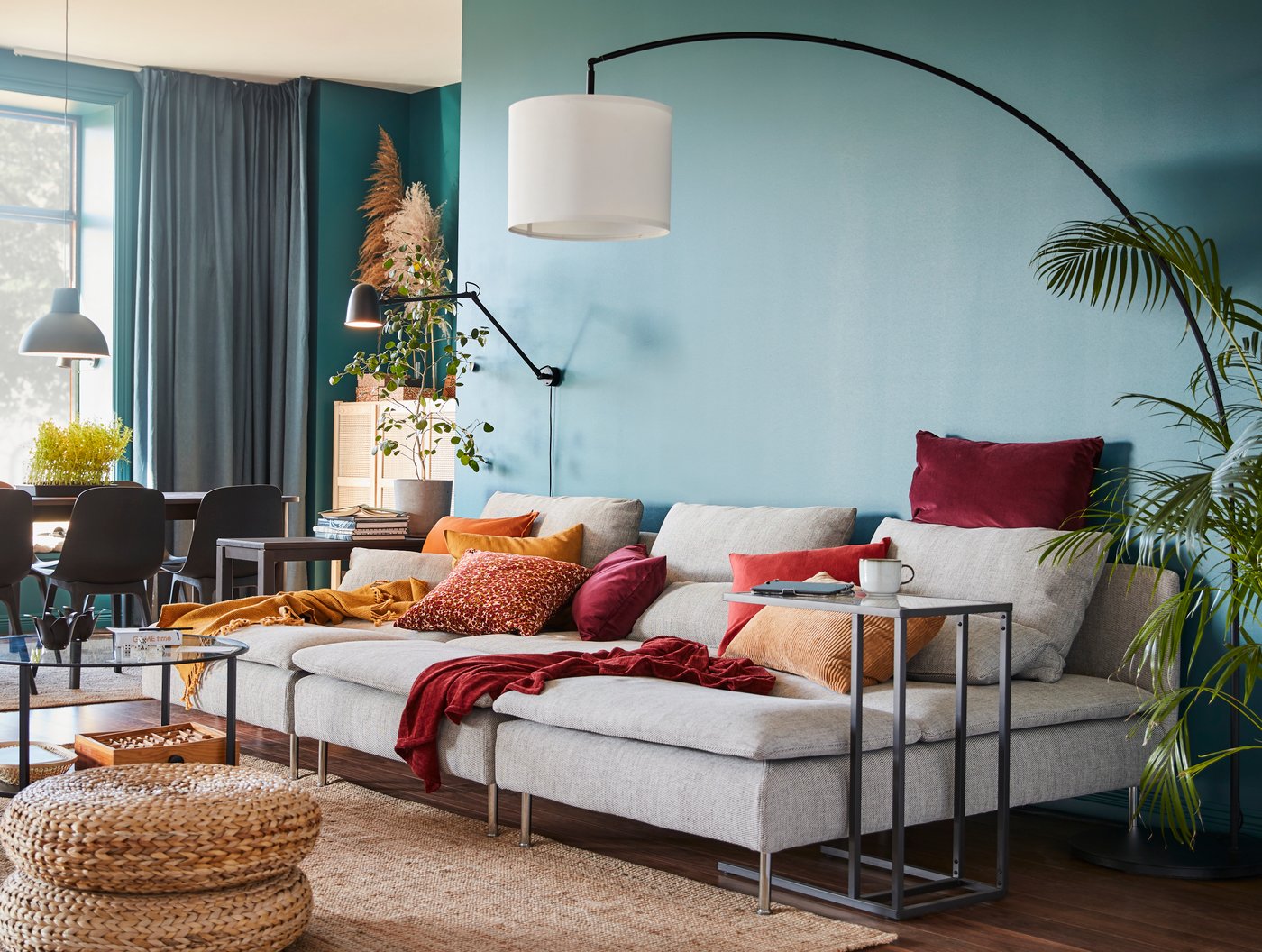 A SKURUP wall lamp is mounted on the wall above three SÖDERHAMN chaise lounges in a colourful living room.