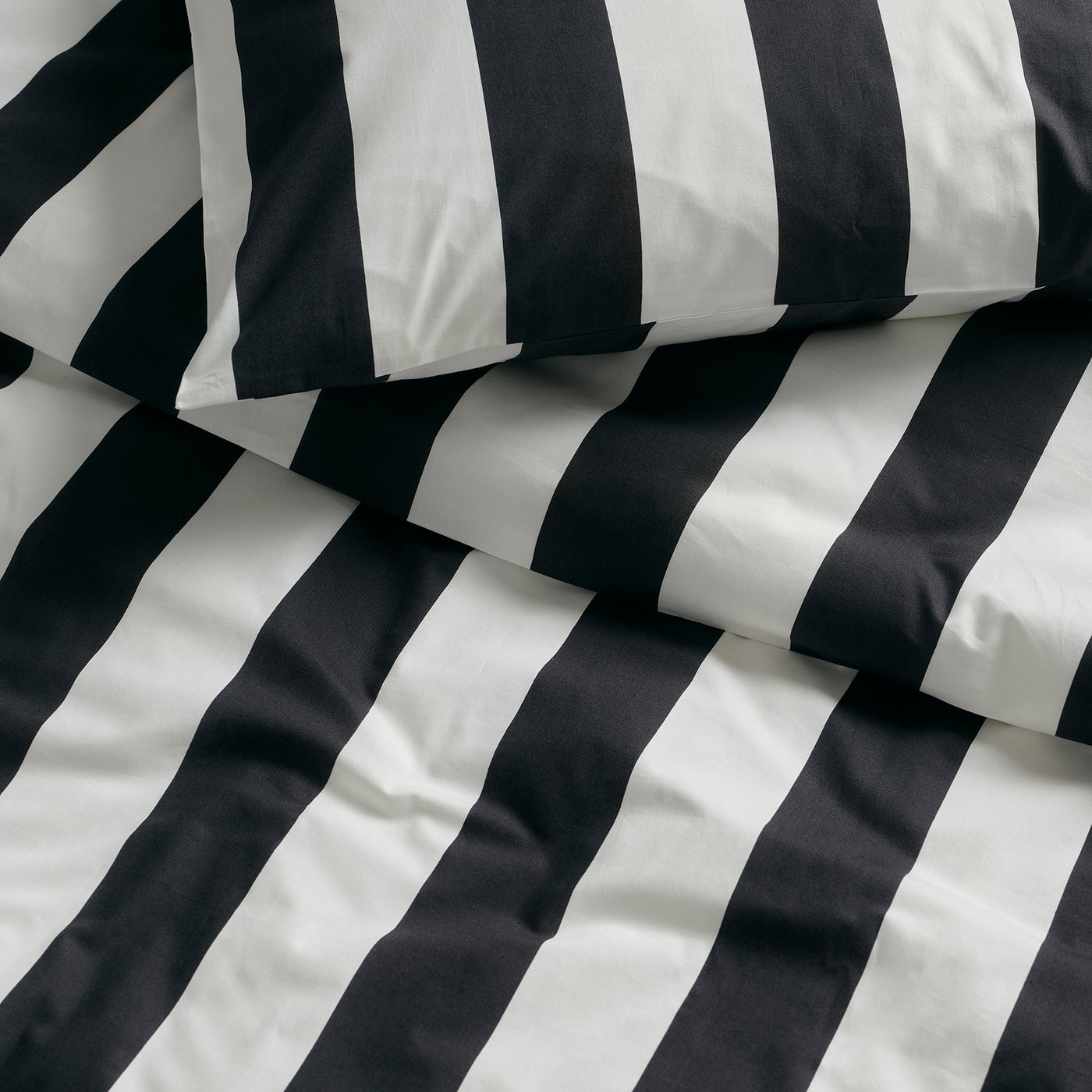 A black/white/striped SLÅNHÖSTMAL duvet cover and pillowcase