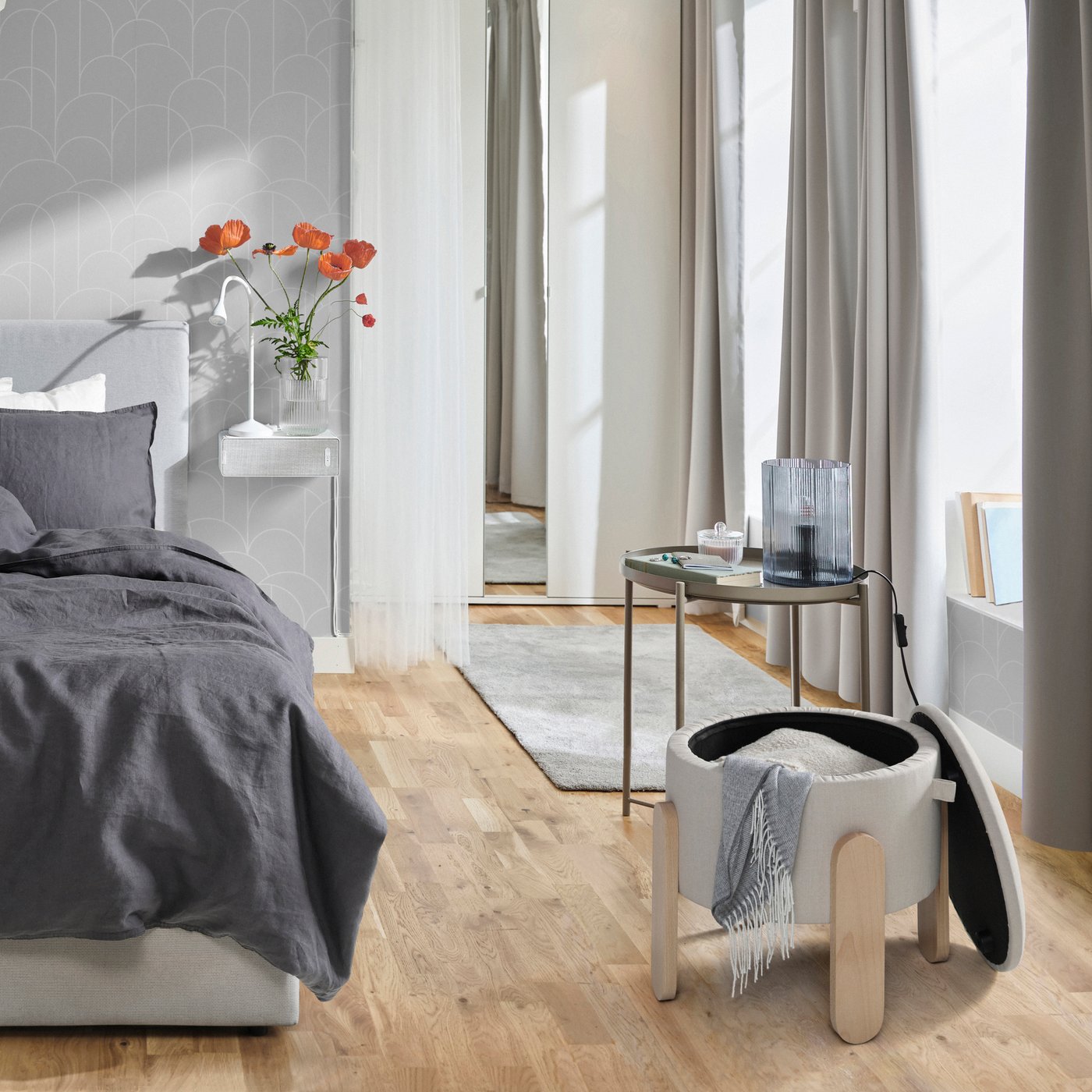 A white NÄVLINGE LED work lamp in the bedroom