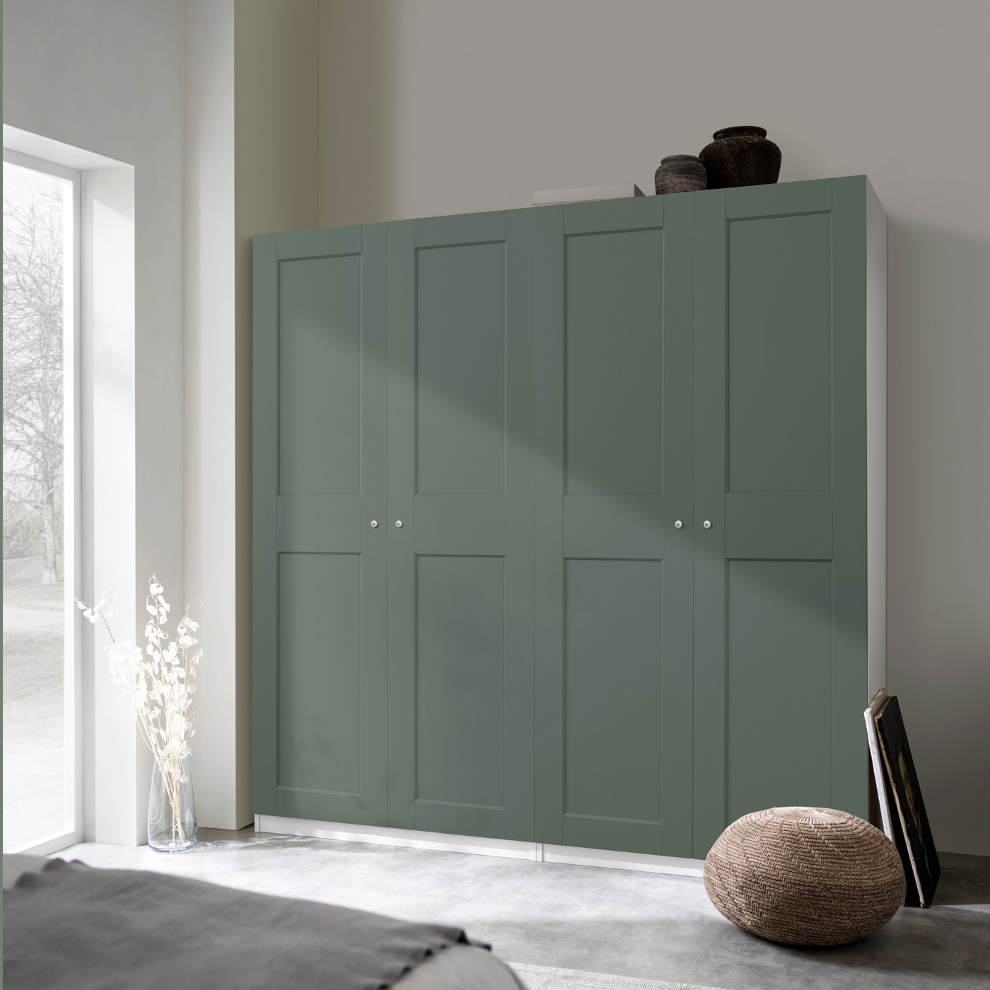 Une armoire-penderie PAX blanc/gris-vert dans une chambre à coucher