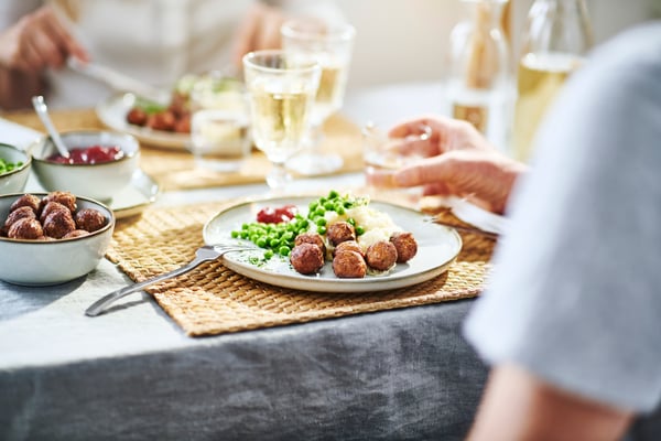 Ett uppdukat bord med en tallrik med köttbullar på.