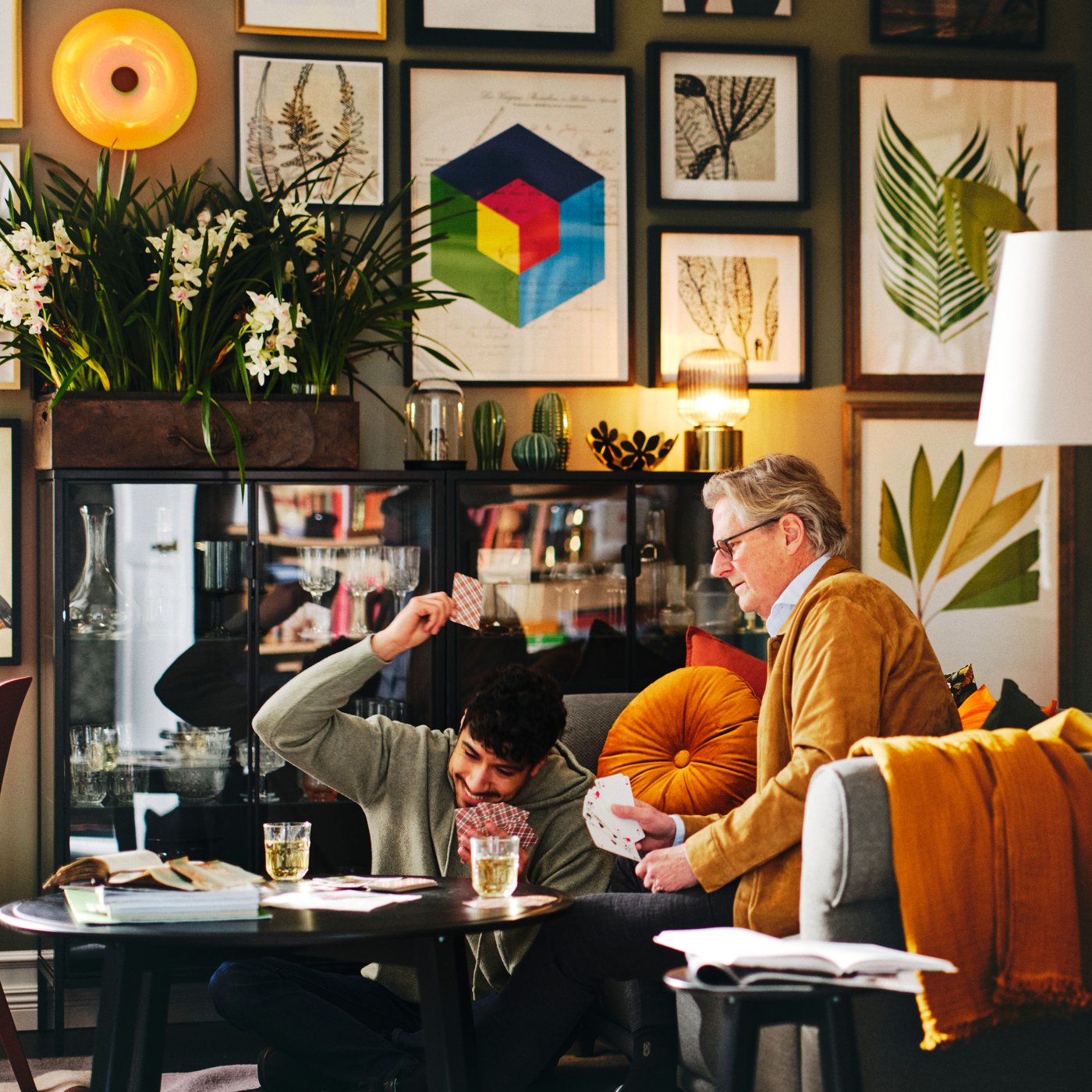 A father and a son playing cards in a perfectly lit living room.