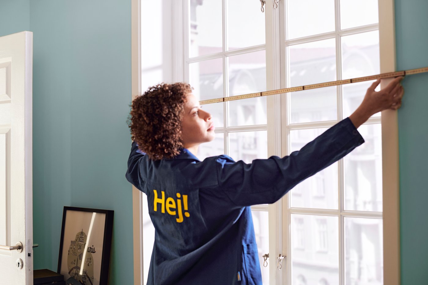 Женщина измеряет окно