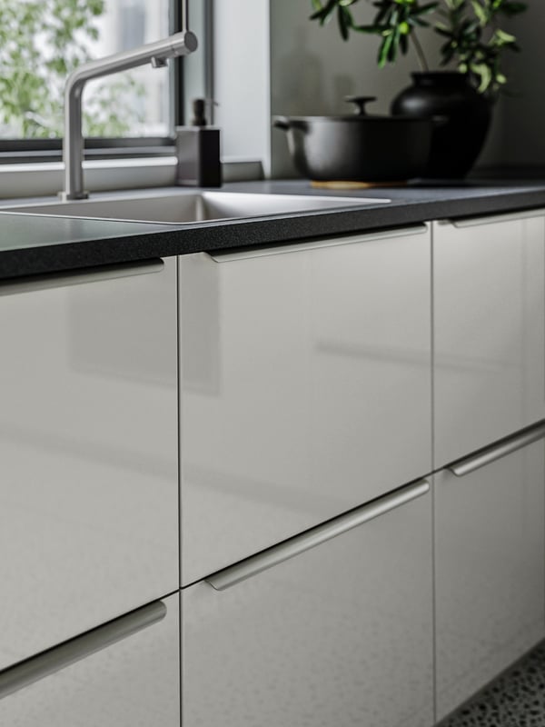 A white high-gloss kitchen with long handles.