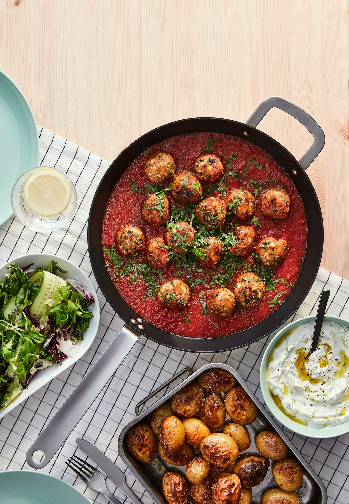 Ricetta di polpette vegetali in salsa di pomodoro e salsa tzatziki, ispirata ai sapori greci.