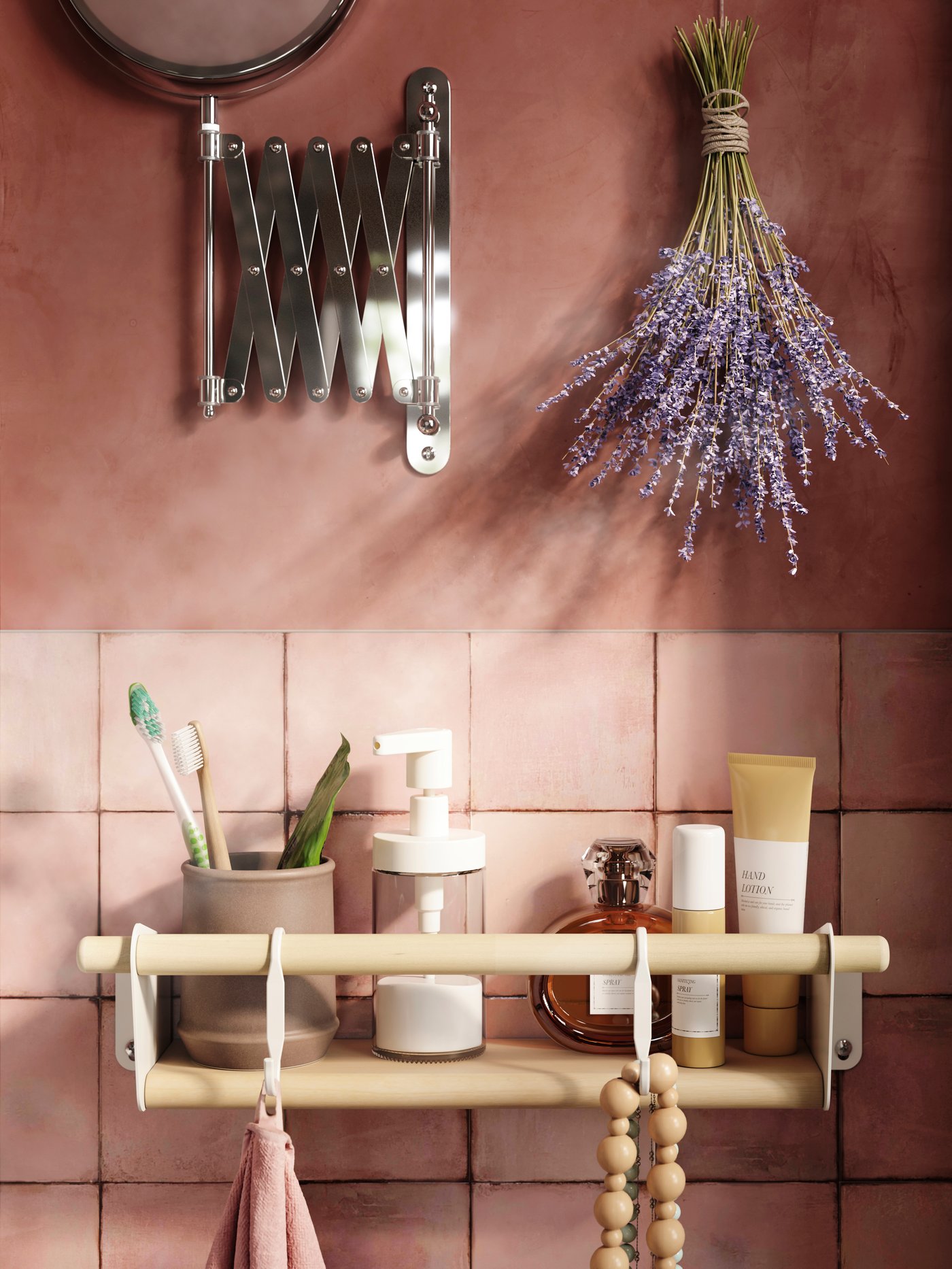 Primer plano de una estantería de pared NEREBY beige con artículos de tocador, montada en una pared de azulejos rosas bajo un bulto de lavanda y un espejo.