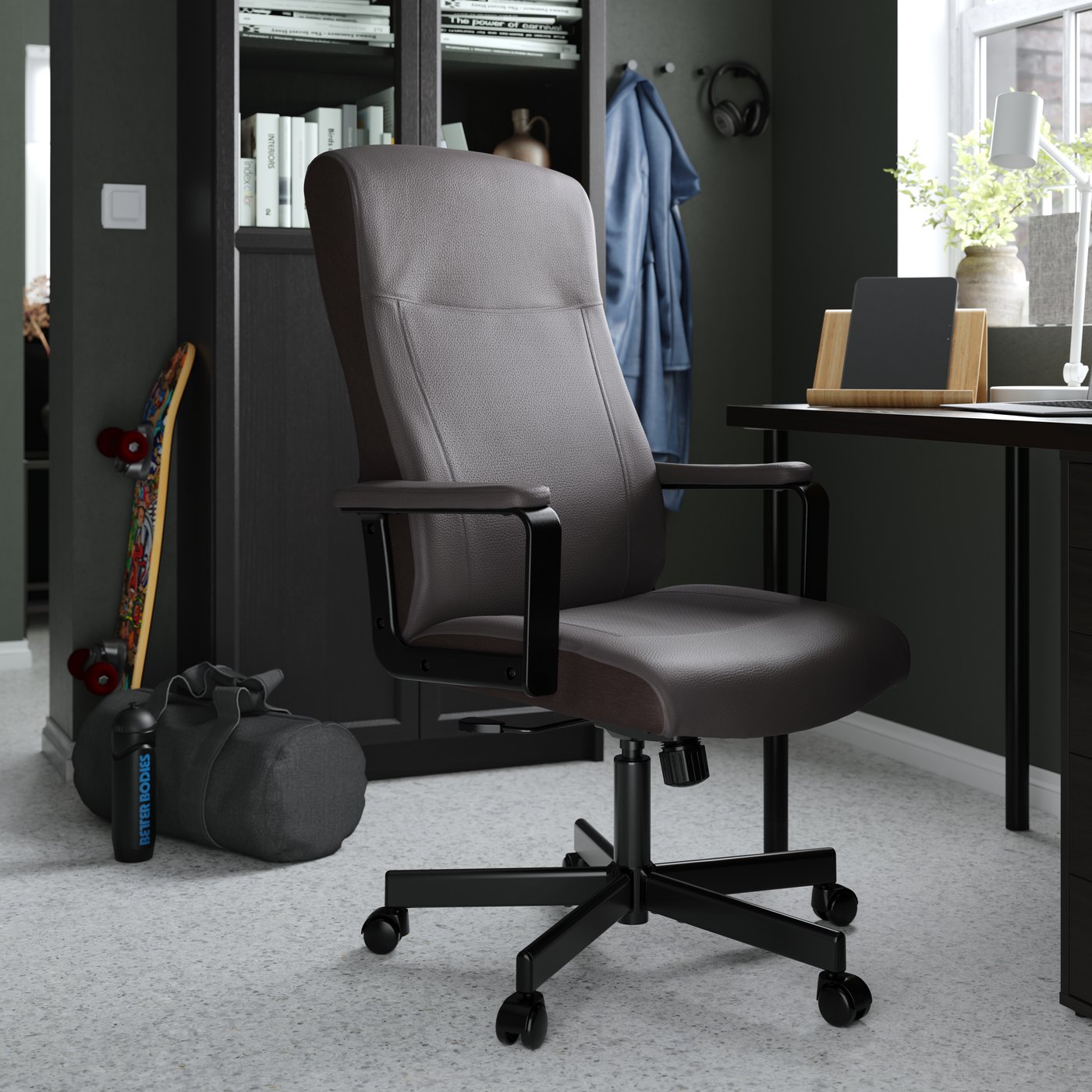 Una silla de oficina MILLBERGET negra frente a un escritorio.