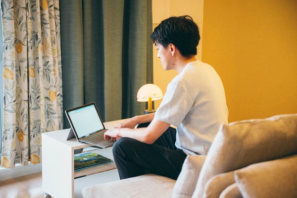 リビングスペースでPC作業をする相談者