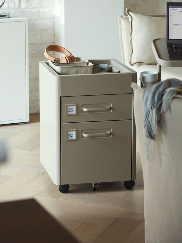 A beige IDÅSEN drawer unit on castors