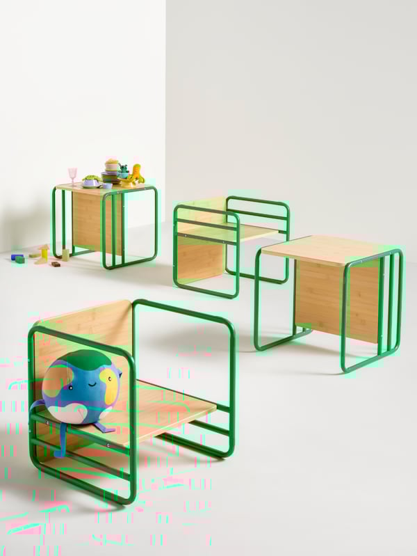 Una stanza bianca con quattro sedie/tavoli multifunzione per bambini SMÅSKRAKE e alcuni giocattoli.