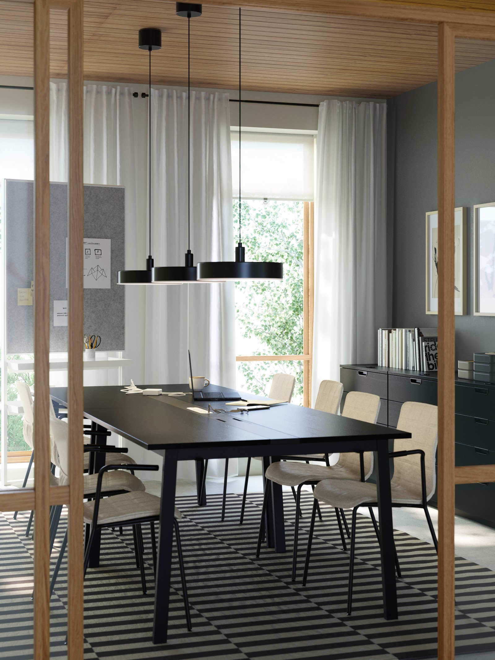 A modern meeting room with four black MITTZON conference tables, six LÄKTARE chairs in light wood and a striped wool rug.