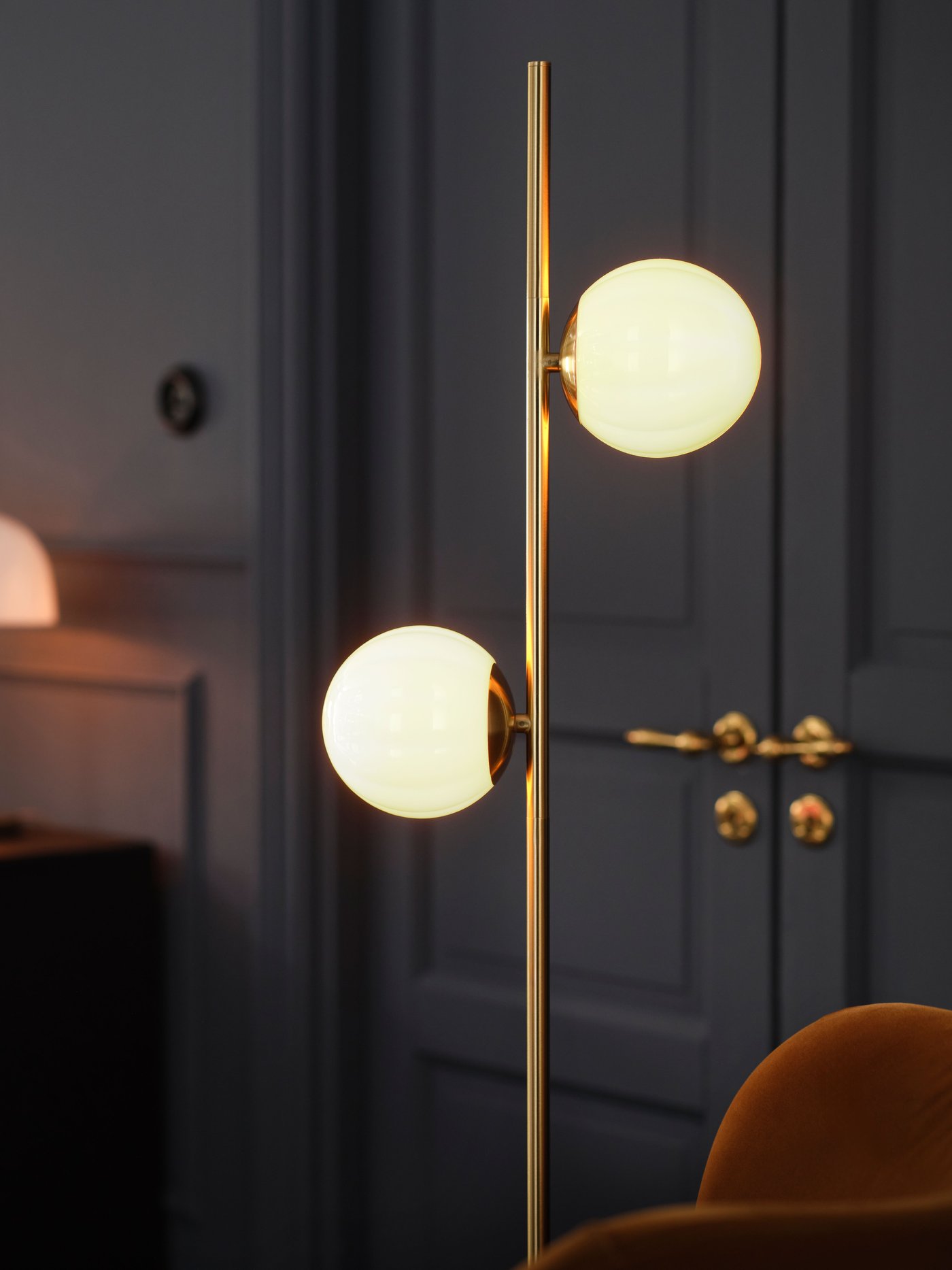 Lampa stołowa AKTERSPRING z mlecznobiałego szkła i mosiądzowanego metalu w salonie