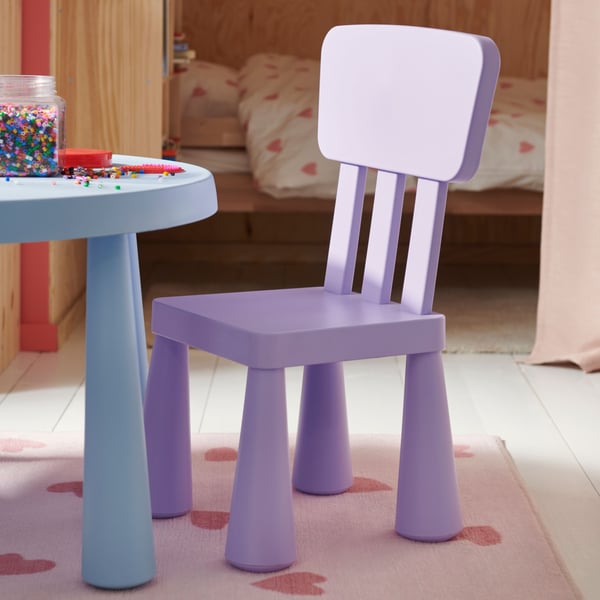 A lilac MAMMUT children’s chair in front of a blue MAMMUT children’s table on top of a BARNDRÖM pink rug.