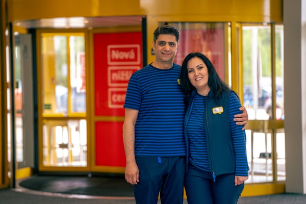 Silva and Abdul in their blue IKEA work uniforms holding each other.