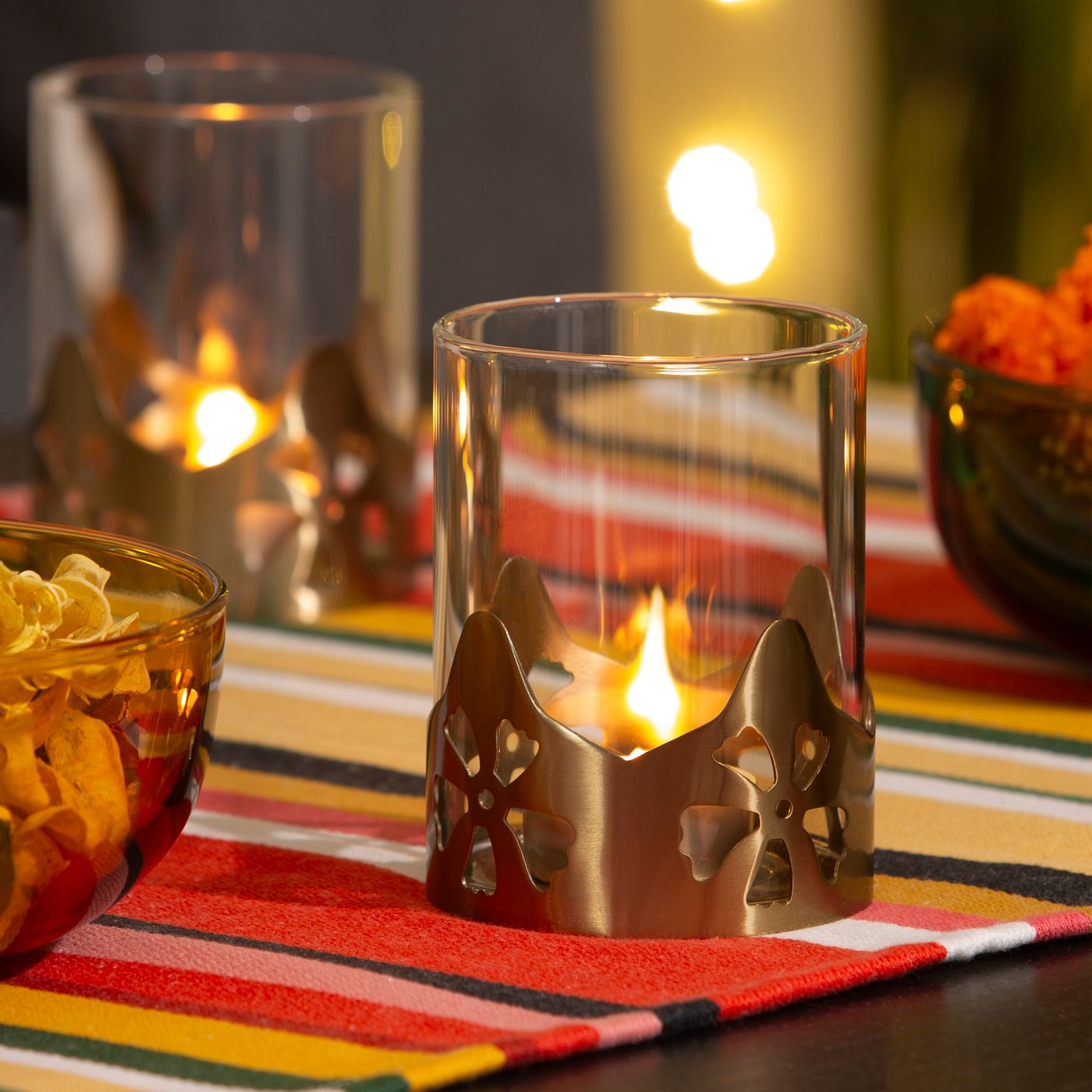 En AROMATISK värmeljushållare i glas med guldfärg.