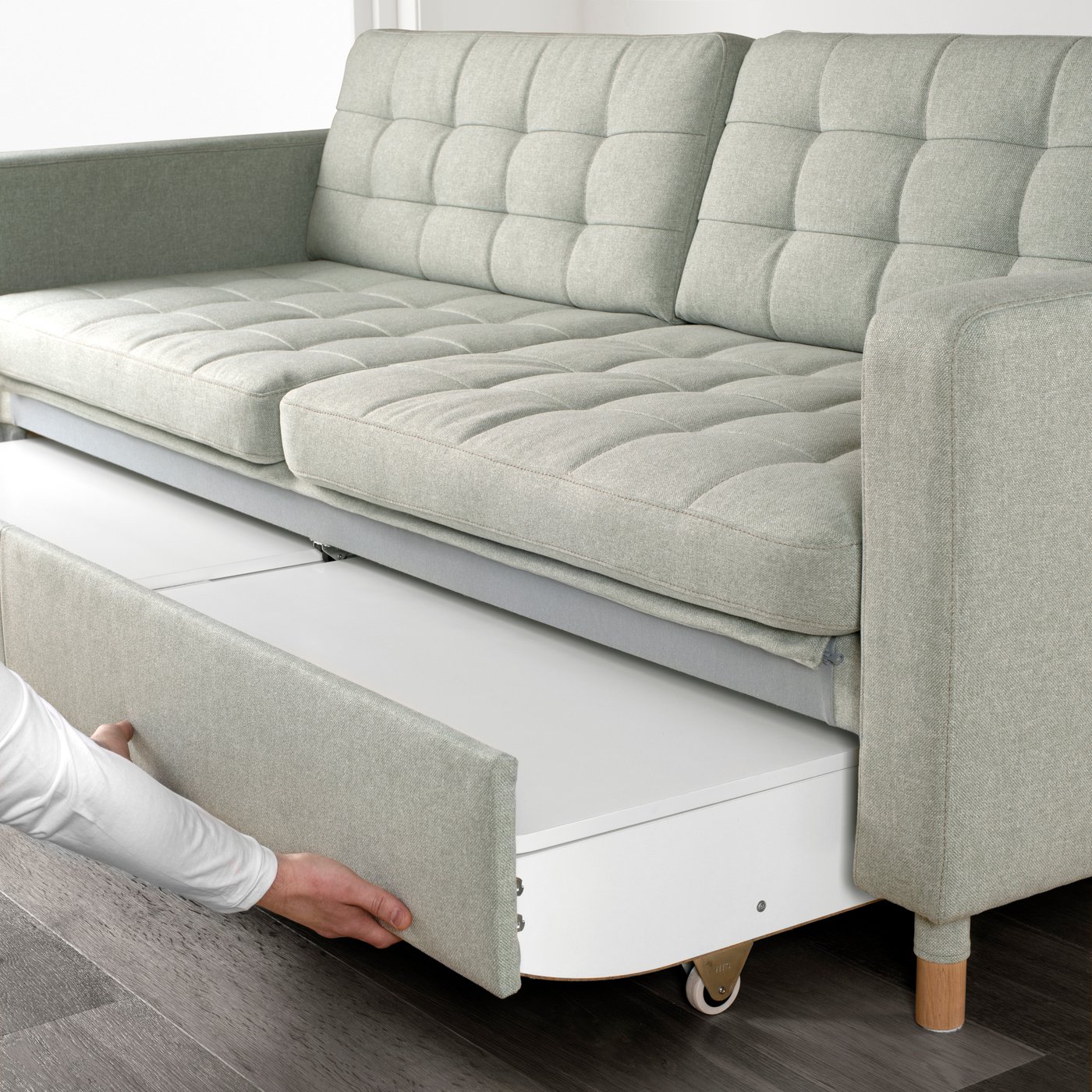 Zu sehen ist ein LANDSKRONA 3er-Bettsofa mit Bezug „Gunnared“ in Hellgrün mit Holzbeinen
