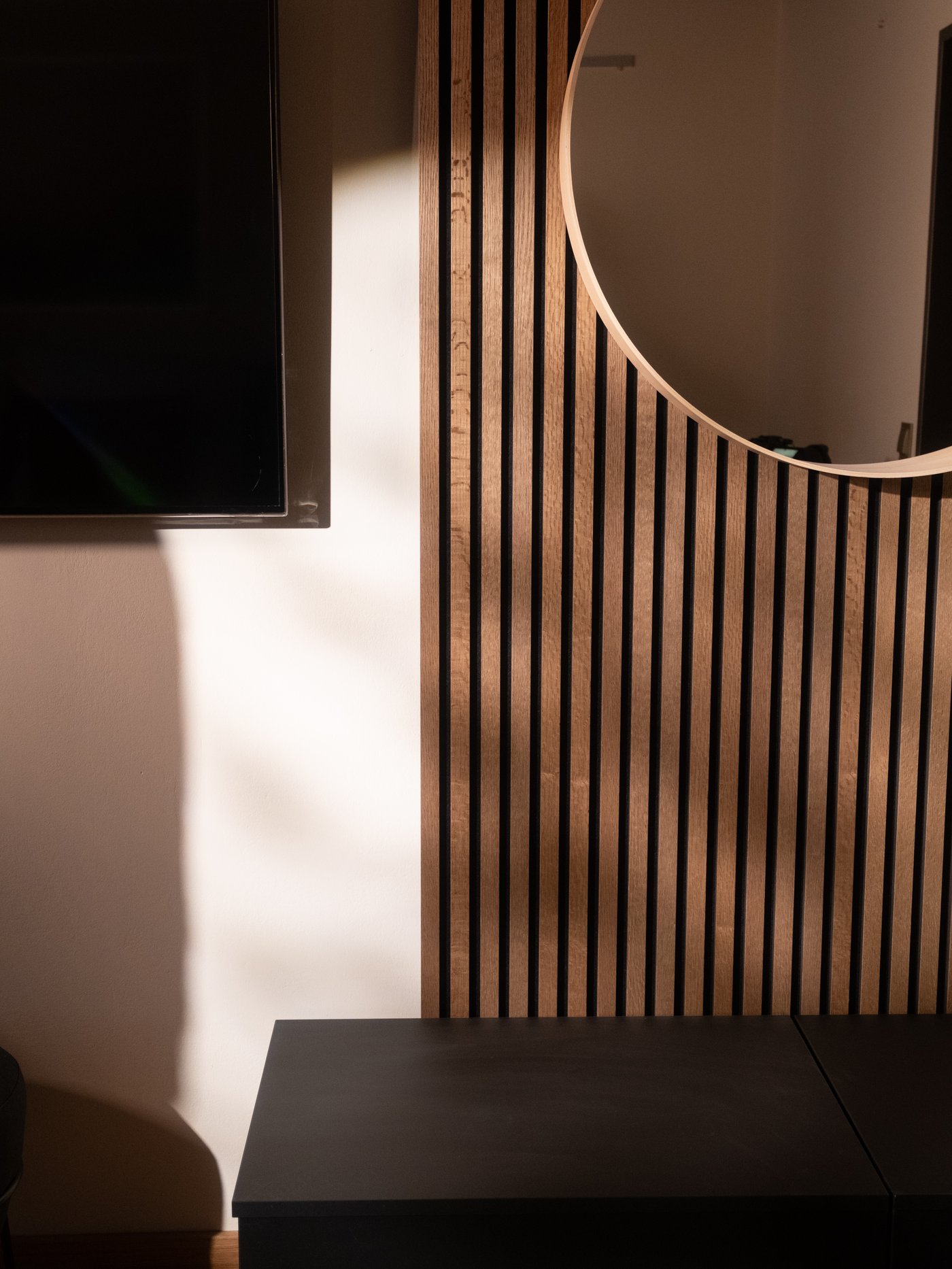 Ein Blick auf eine holzbetäfelte Wand, an der ein LINDBYN Spiegel hängt.