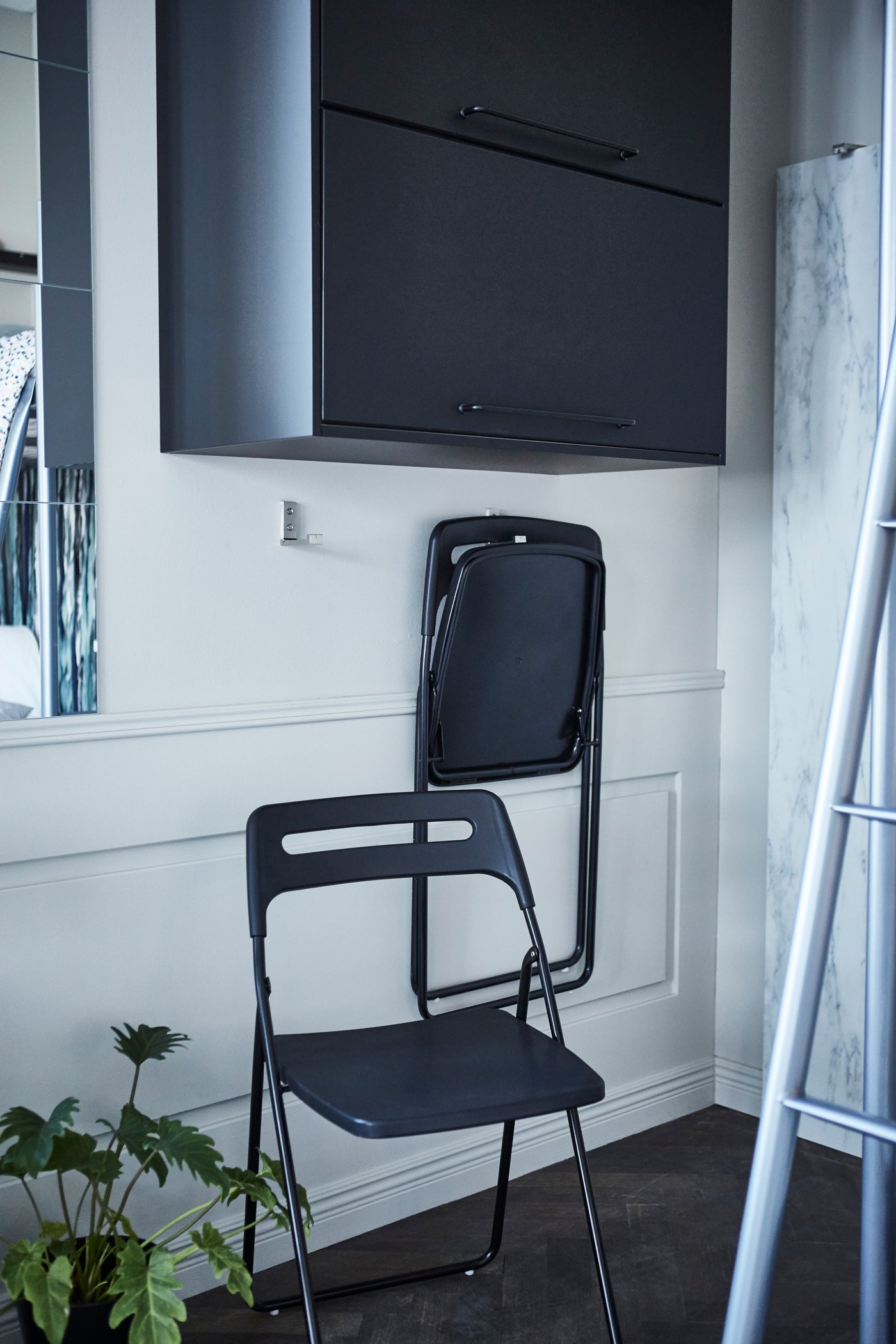 Wird der NISSE Klappstuhl gerade nicht benötigt, kann er auf einen Haken an der Wand verwahrt werden.