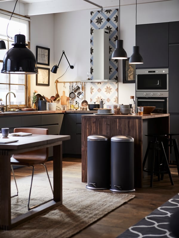 A METOD kitchen with a kitchen tile backsplash, wooden kitchen island and two MJÖSA pedal bins.