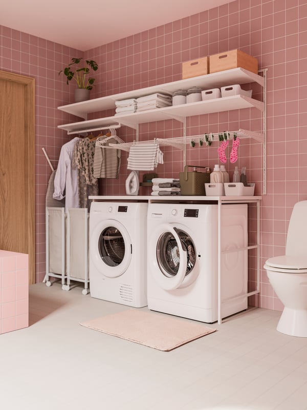 Un bagno rosa con scaffalatura BOAXEL bianco nella zona lavanderia