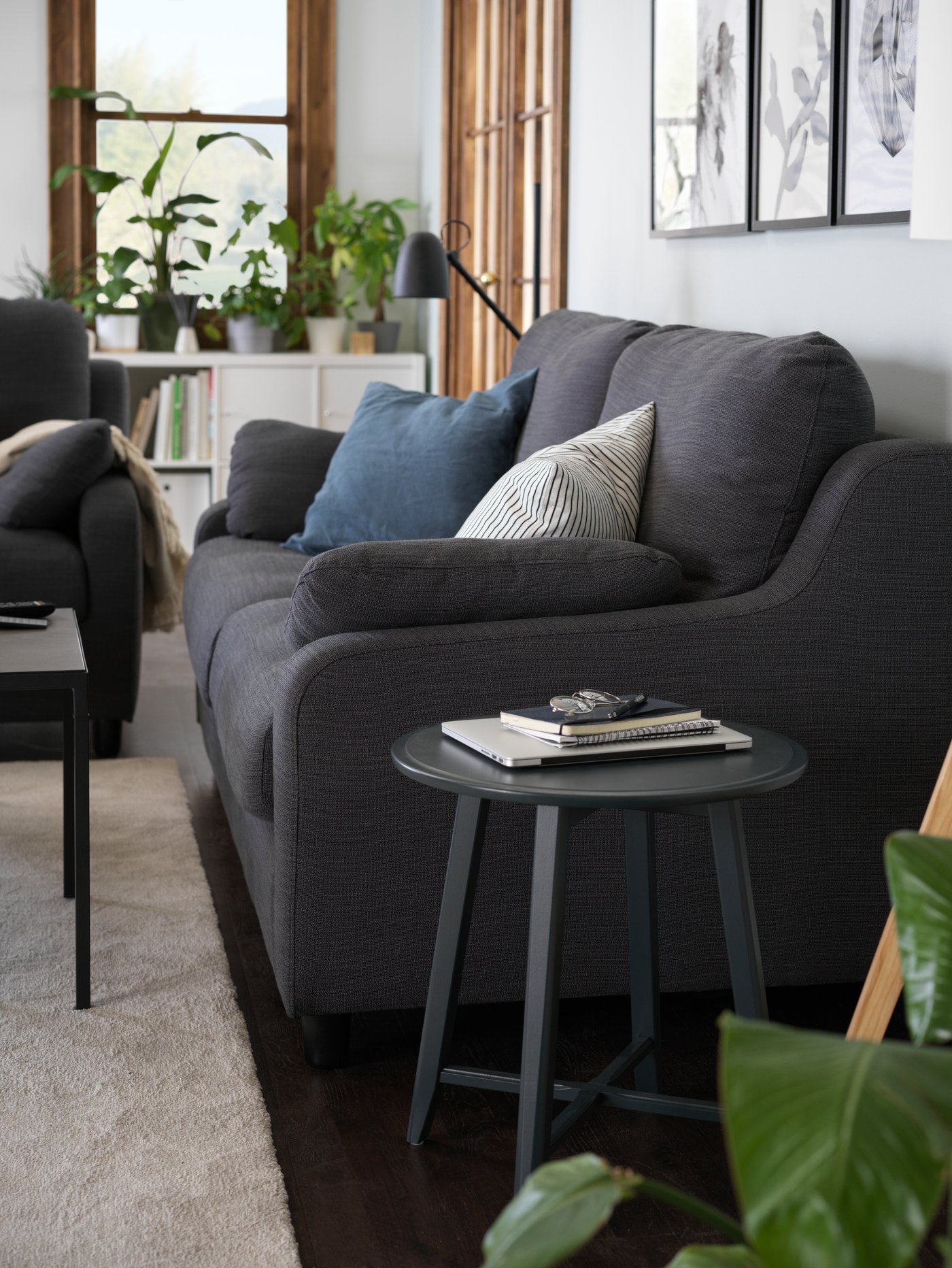 A dark blue-green colour KRAGSTA nesting table next to a VINLIDEN three-seat sofa.