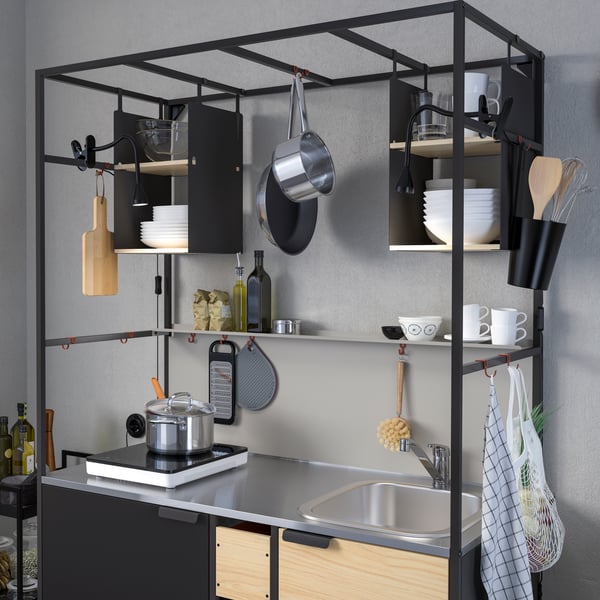 A black/ash ÄSPINGE kitchenette sits against the wall filled with kitchen accessories.