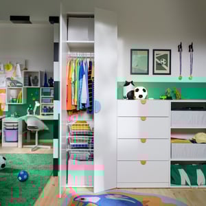 A kids’ room with a LASTARE wardrobe combination with storage, hanging rail and drawers next to a workspace and play area.