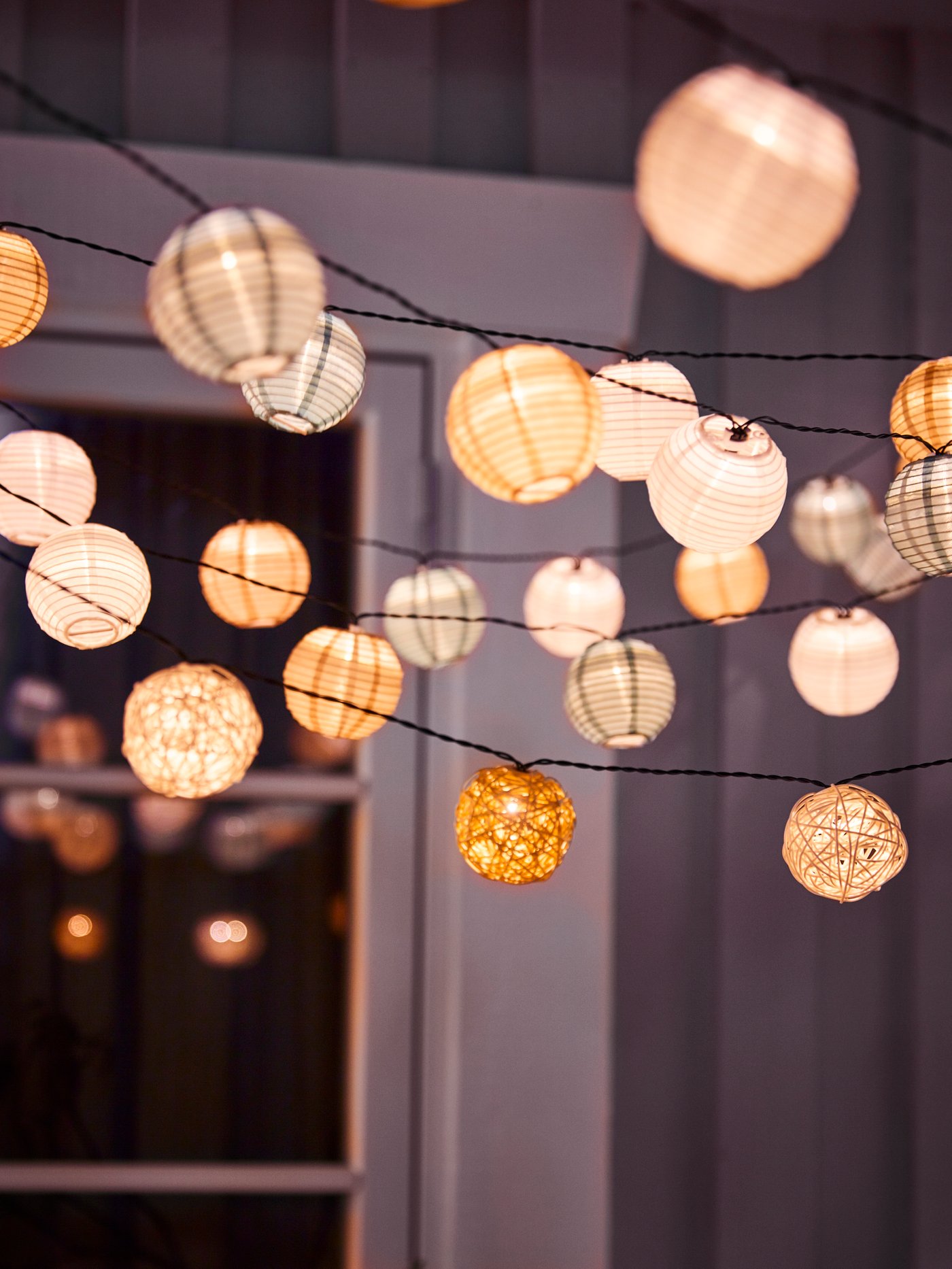 A battery-operated/white beige SOLVINDEN LED lighting chain with 12 bulbs outside