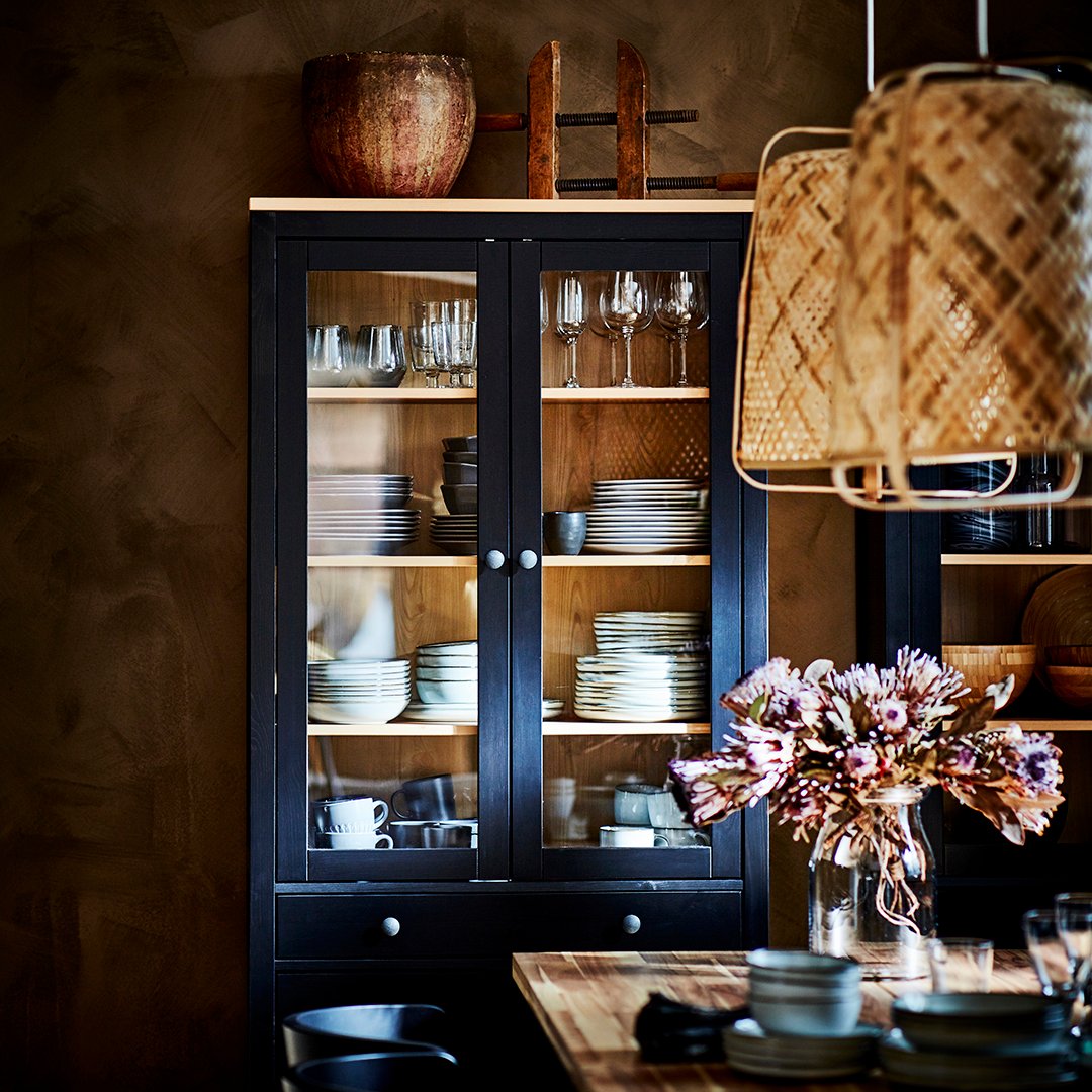 A black-brown/light brown HEMNES glass-door cabinet with 3 drawers in the dining room