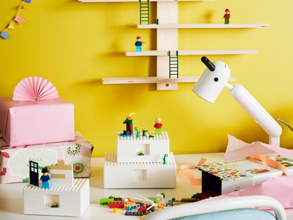 Caja blanca con LEGO BYGGLEK junto a más juguetes infantiles.