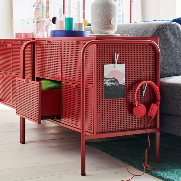 Duas cómodas NIKKEBY, com um par de auscultadores e um desenho presos numa das laterais, ao lado de um sofá FLOTTEBO.