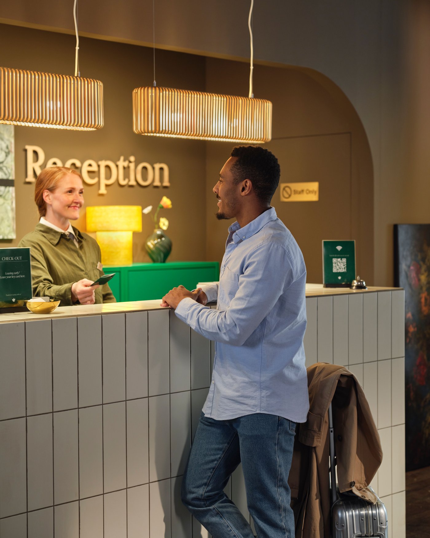 A person is checking into a hotel and is talking to the person at the front desk.