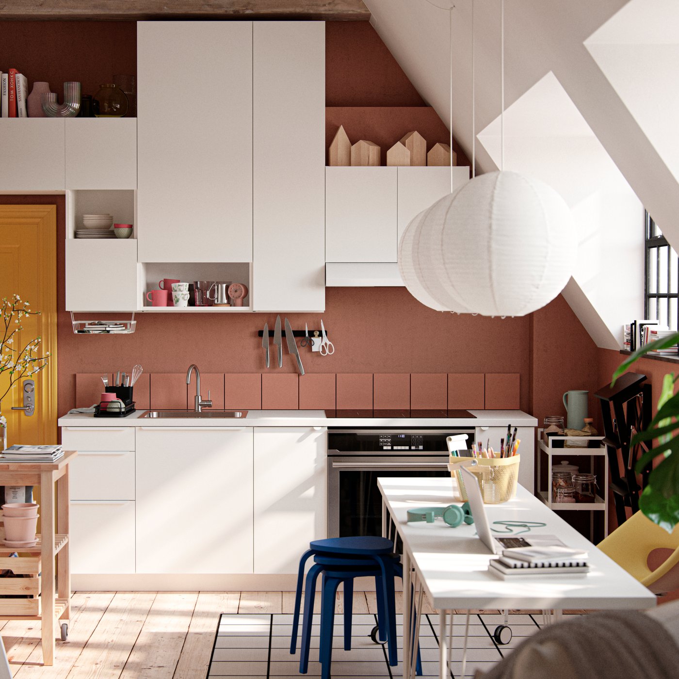 A studio apartment with large industrial-style windows, dark terracotta-coloured walls and white VALLSTENA kitchen fronts.