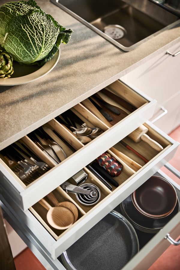 A magnetic rack organises kitchen utensils and a wall shelf holds wooden cutting boards.