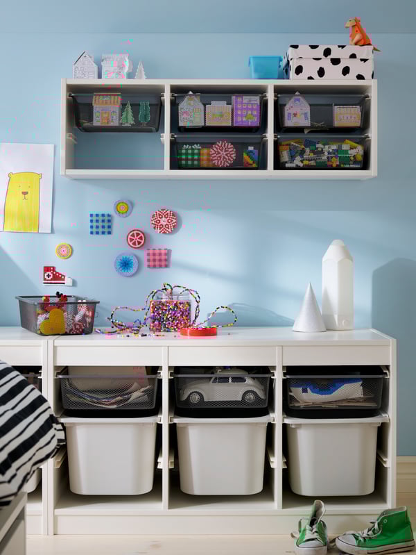 TROFAST storage unit both on the floor and wall-mounted, with a mix of mesh and plastic boxes, a mix of toys in neat order.