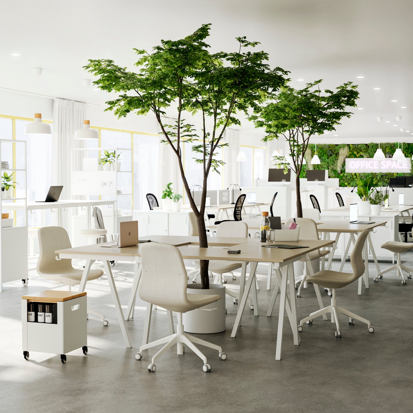 An open office with several groups of beige/white desks and chairs put together as meeting spots, green plants in between.
