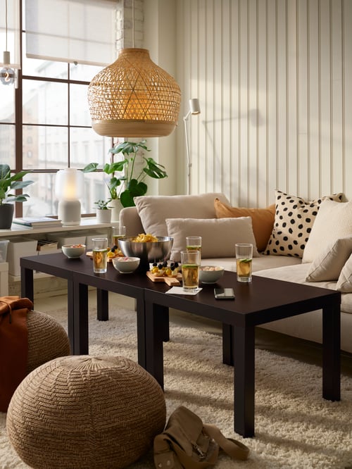 Modernes Wohnzimmer mit zwei LACK Beistelltischen, einer MISTERHULT Hängeleuchte, einem ODDNY Kissenbezug, einem SANDARED Bodenkissen und einem SÖDERHAMN 1er-Sitzelement. Die Beistelltische stehen auf einem VOLLERSLEV Teppich.