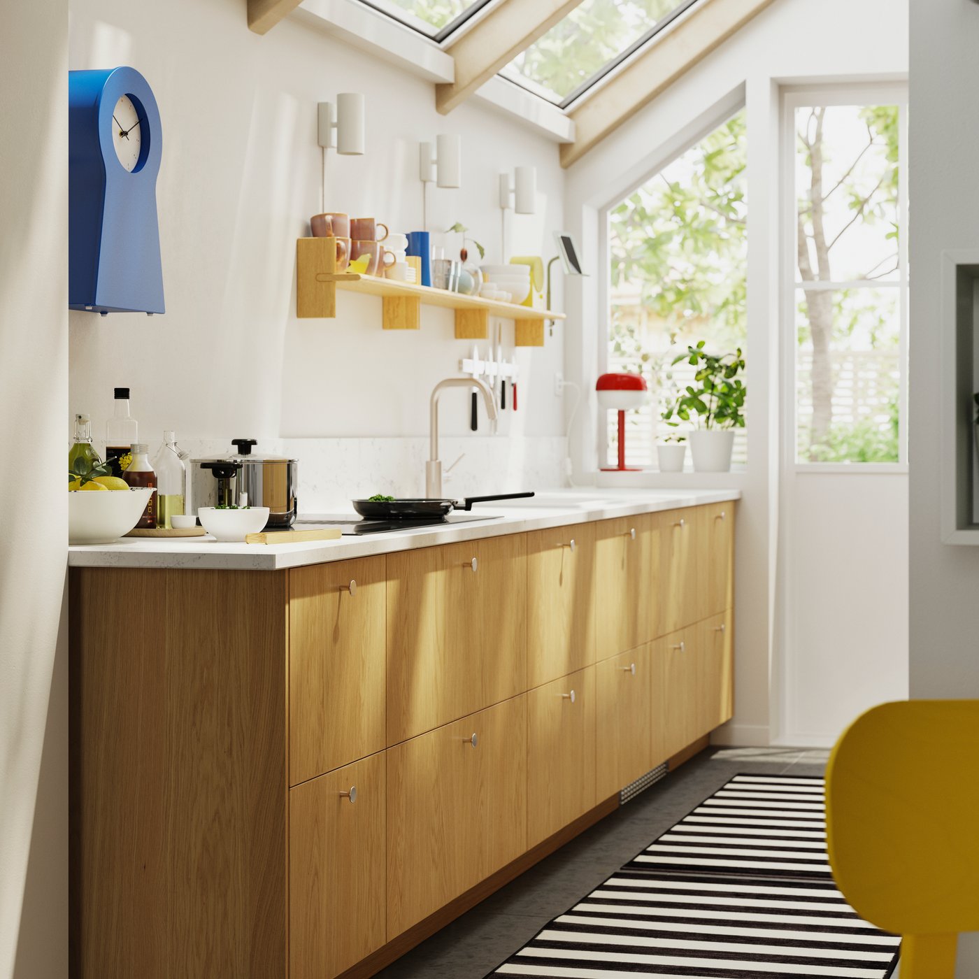 Kitchen cabinets with large drawers and SINARP fronts in oak veneer are mounted in a bright kitchen, forming a big work area.