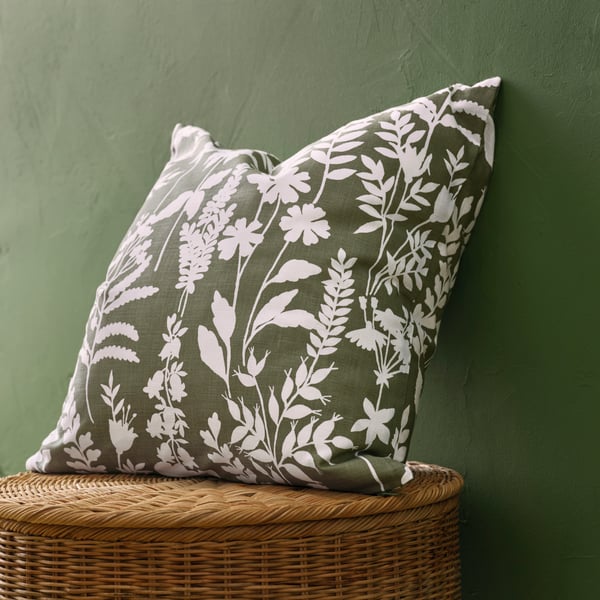 Gros plan sur une housse de coussin ROTVECKLARE au motif de feuilles d’arbres blanches sur fond vert.