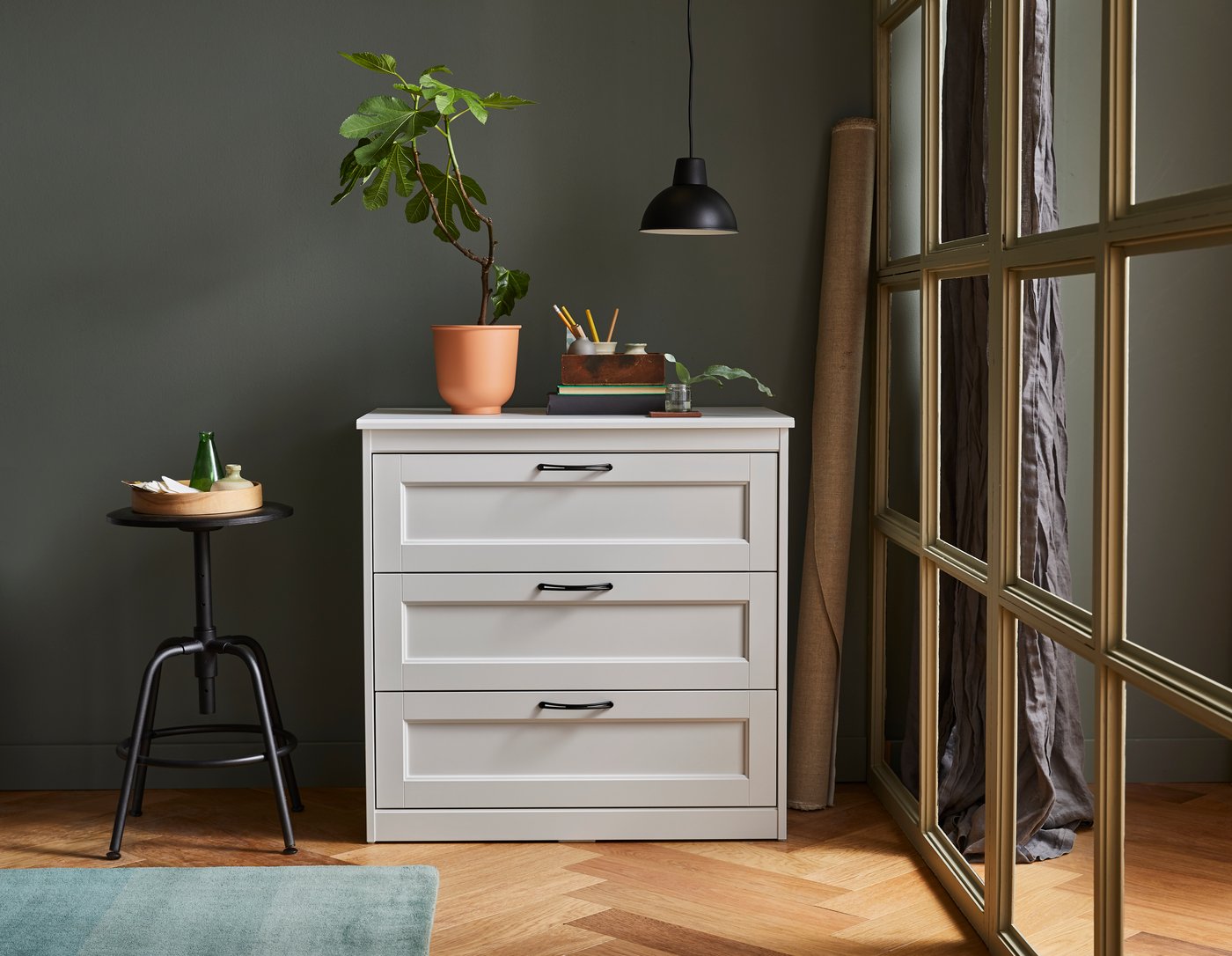 A black KULLABERG stool in the living room