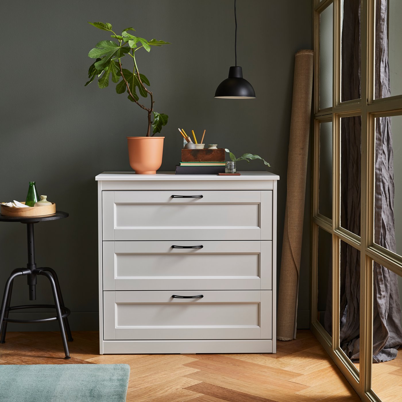 A black KULLABERG stool in the living room