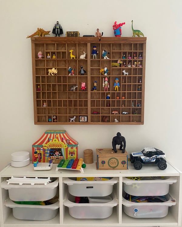 TROFASt Aufbewahrungslösung als Sideboard und Zwei Sammelkästen, die an der Wand hängen.