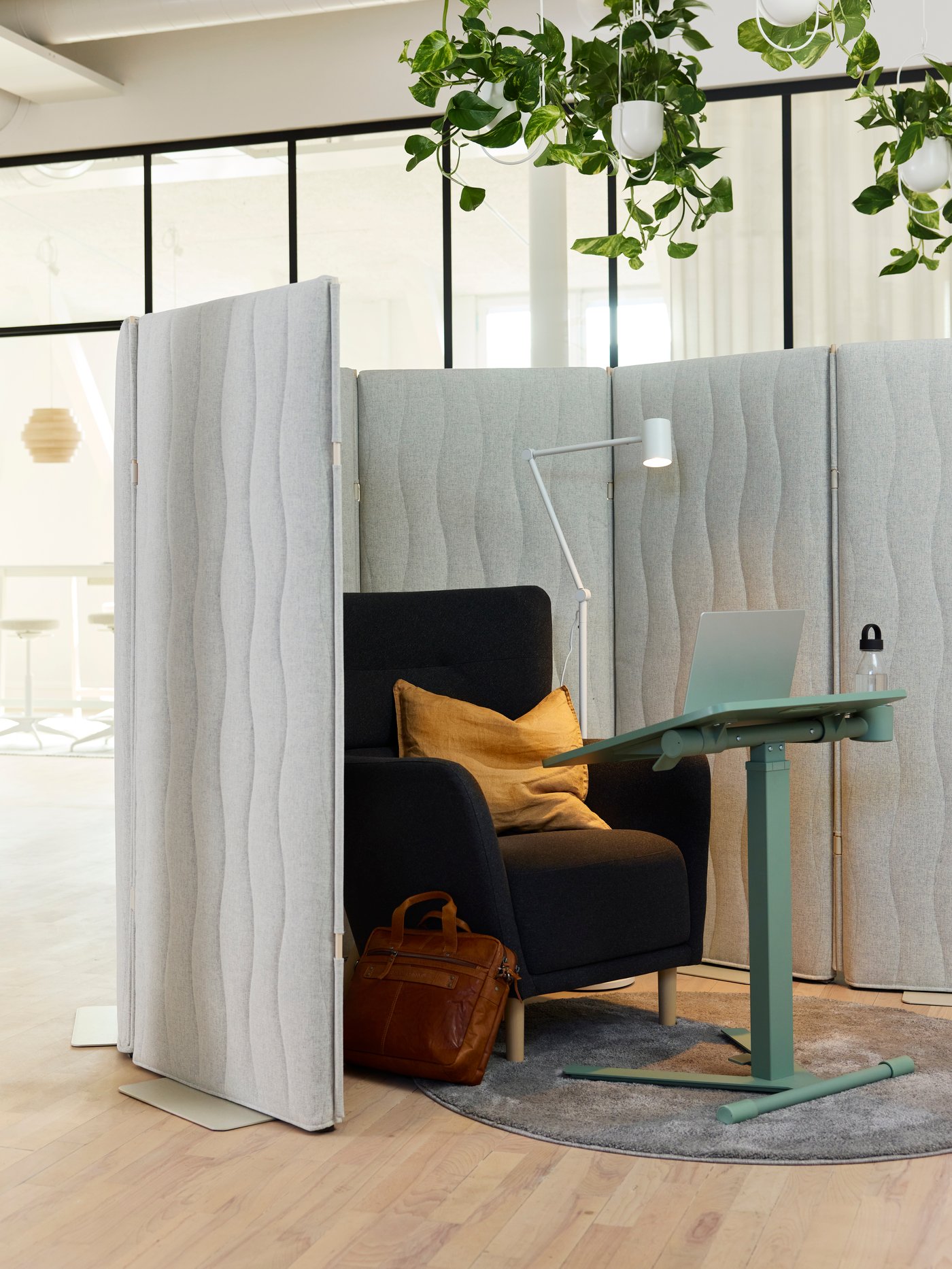 Un angolo dove concentrarsi con poltrona OSKARSHAMN, schermi acustici MITTZON attorno e tavolo per PC portatile MITTZON davanti.